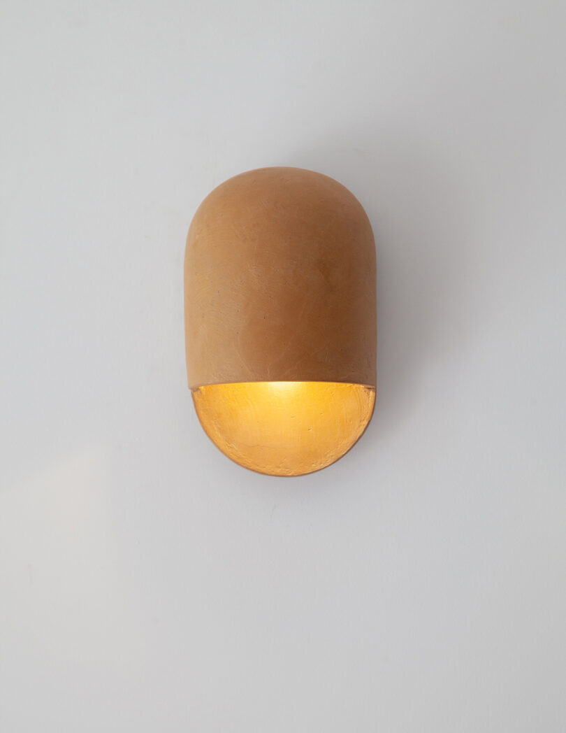 mustard domed ceramic sconces hanging on a white wall