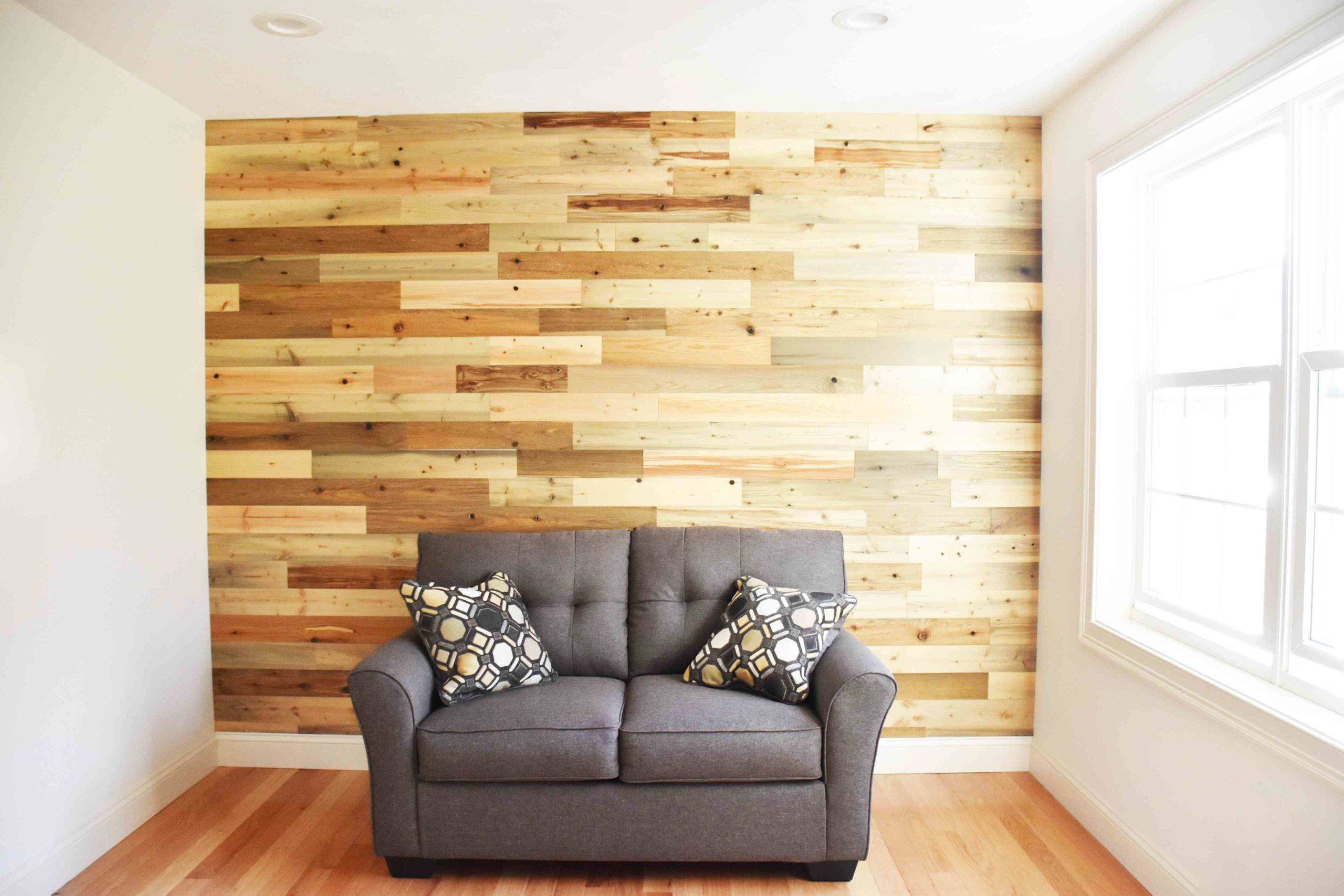 Shiplap wood accent wall fronted by a grey couch.