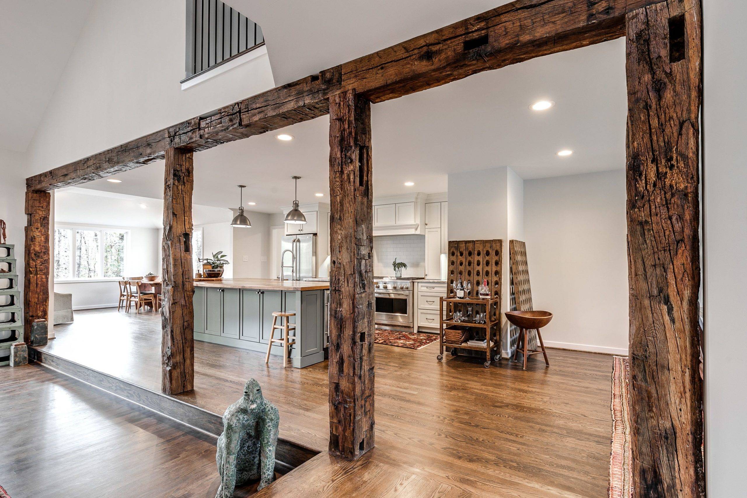 Wooden beam wood accent wall flanked by modern kitchen.