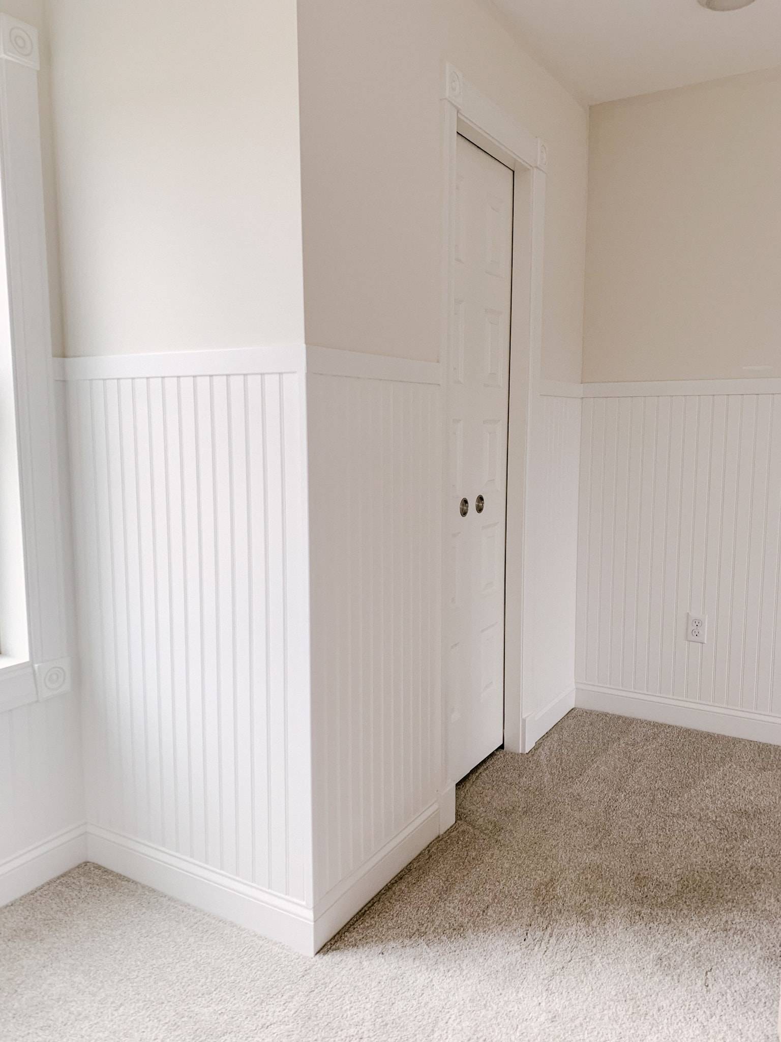 Bead-board walls in a room with carpet.