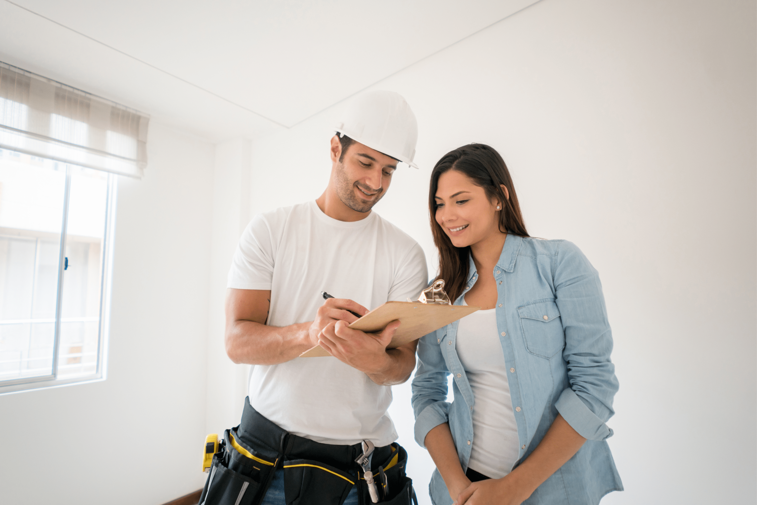 Contractor and woman looking at clipboard.