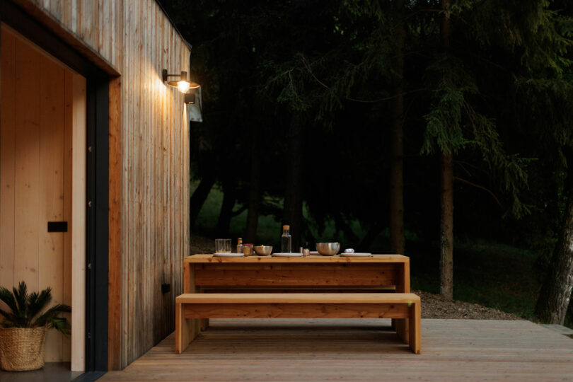 daytime exterior shot of modern wood cabin with a deck