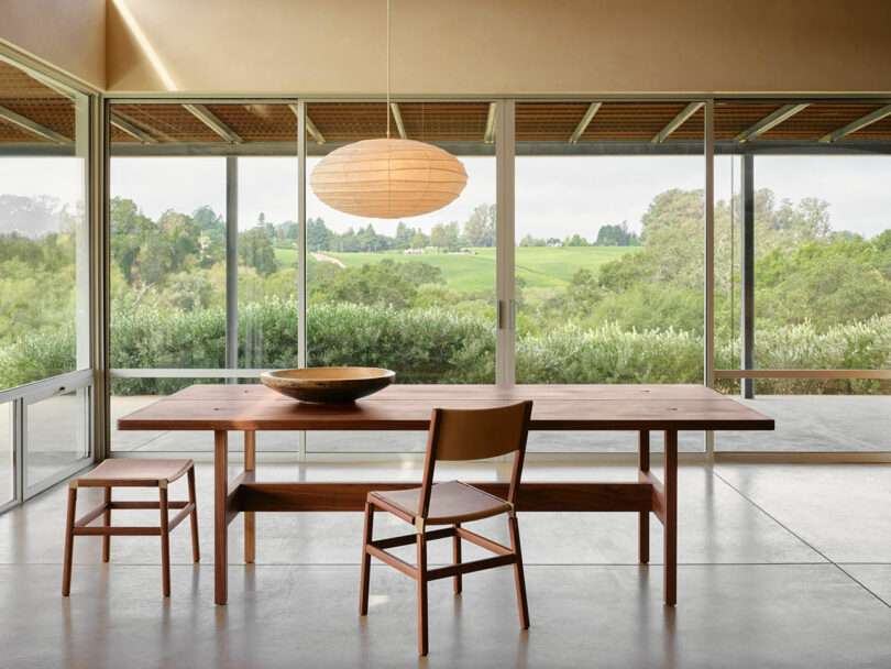 Bright, contemporary space showcasing the table and chairs under a chandelier.