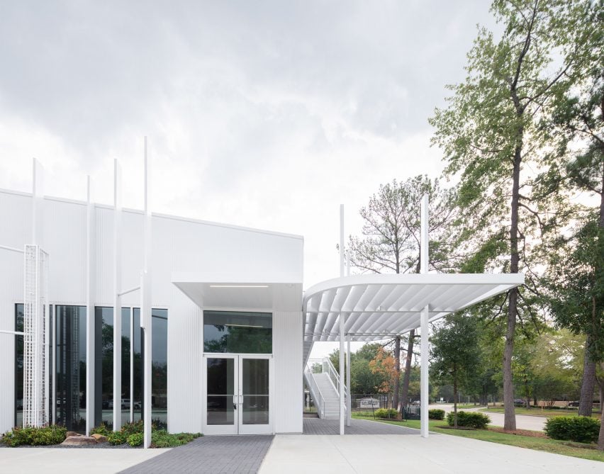 A building with a trellis attached over an exterior walkway