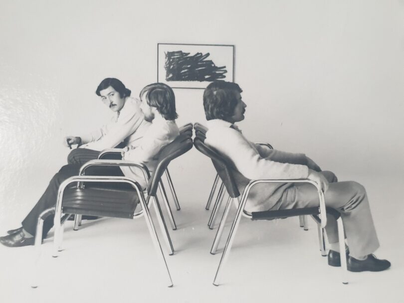 black and white photo of three men sitting in chairs