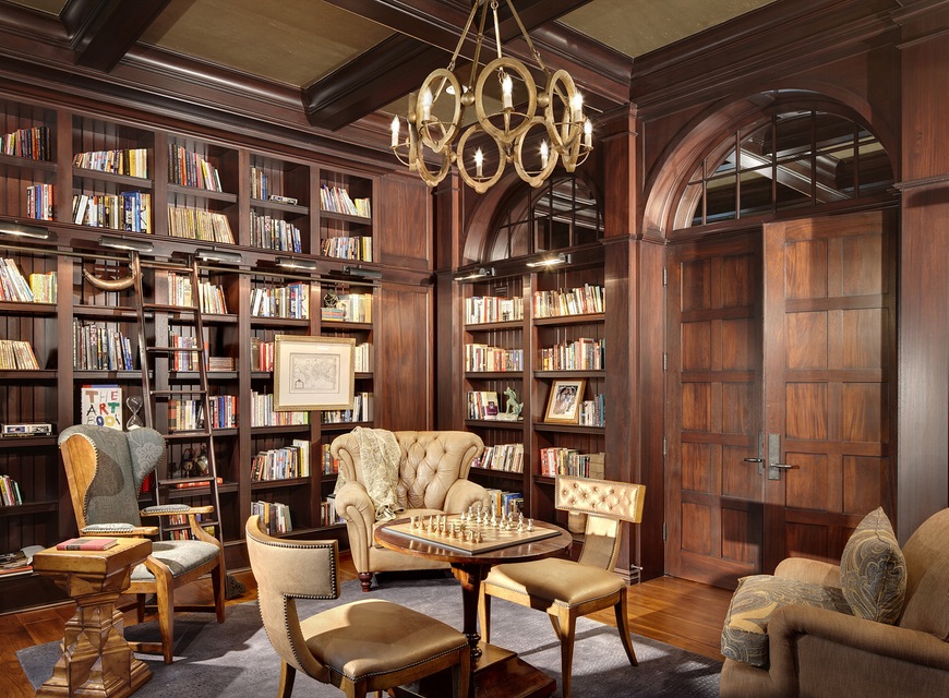 A massive wooden bookcase stands tall, adorned with countless books. Comfortable chairs are scattered around.