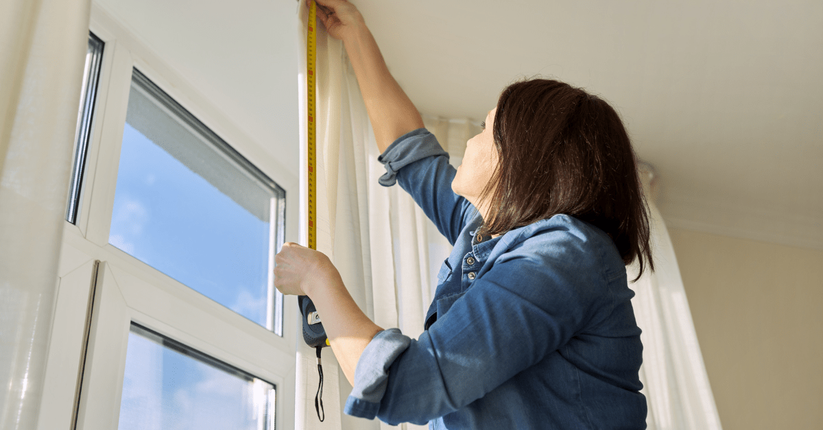 Person using measuring tape for curtains.