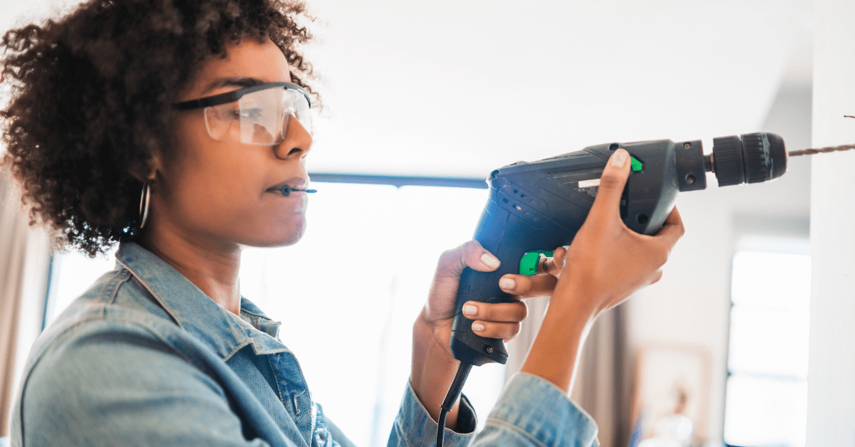 Person using drill while wearing eye protection.