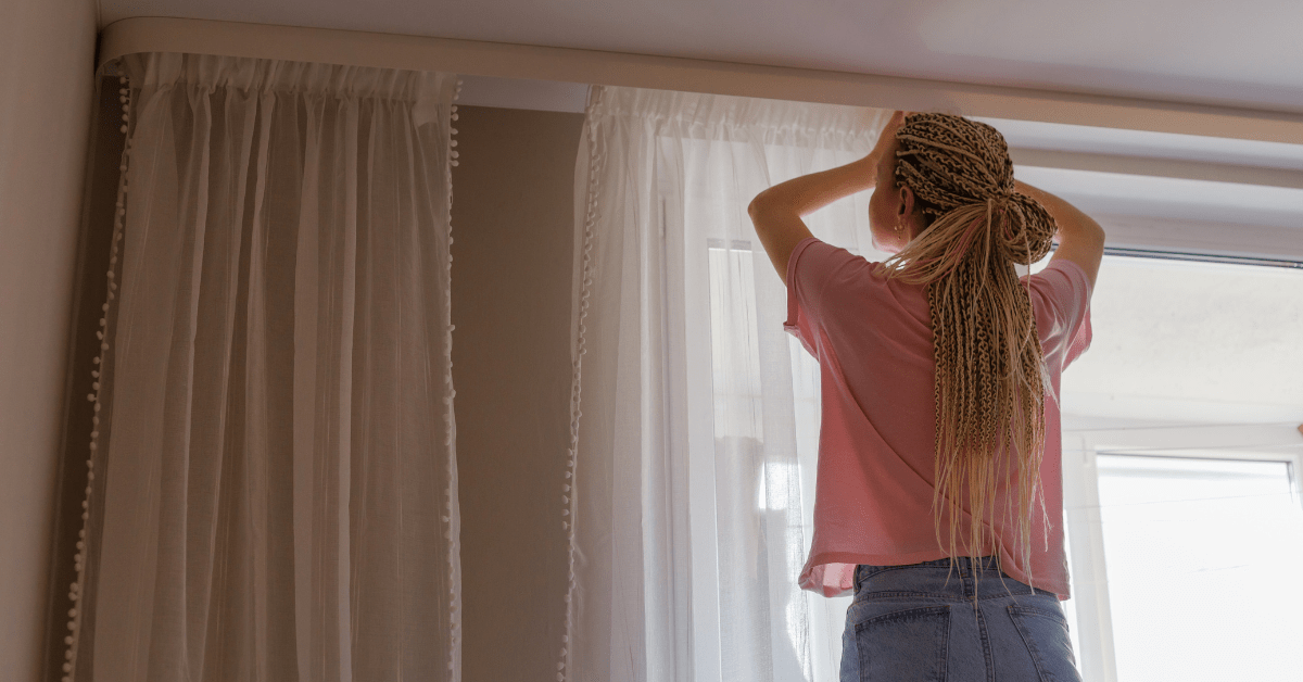 Person adjusting curtains.