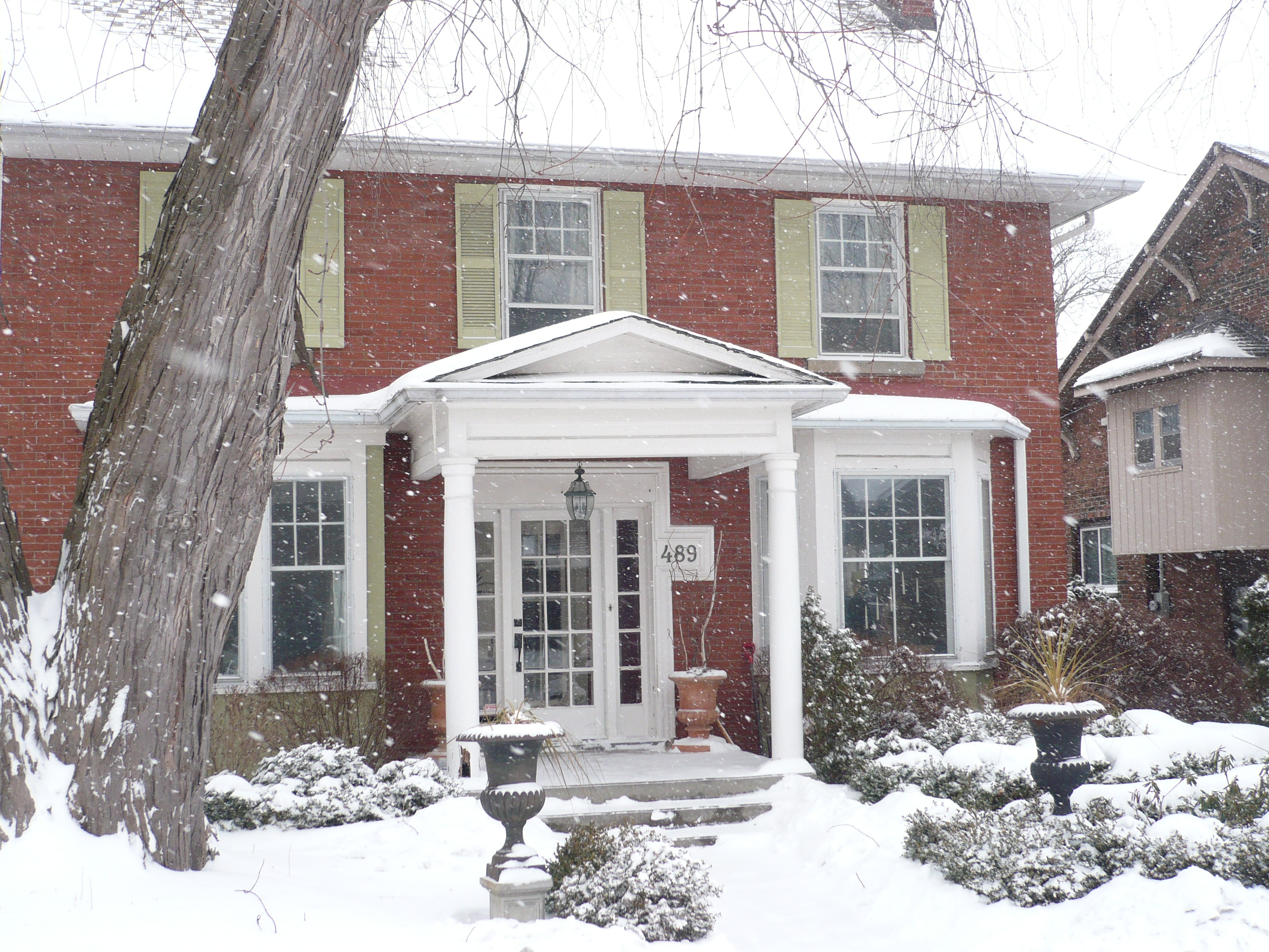 Red brick house covered in snow.