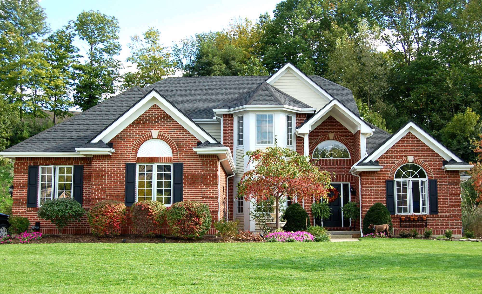 Red brick house with green front grass.