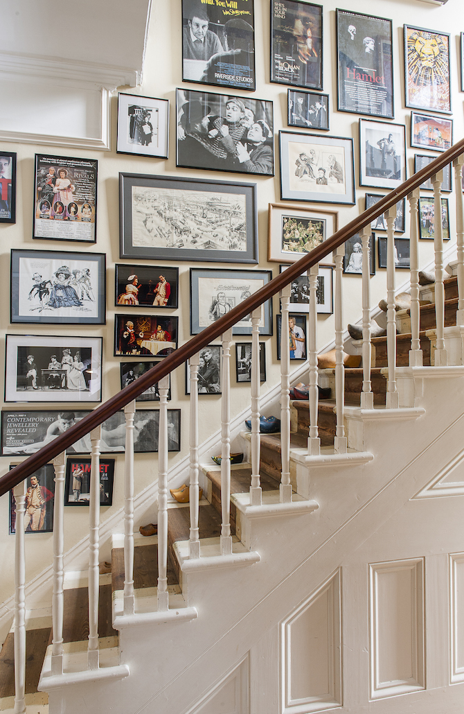 A busy stairway gallery with framed pictures covering almost the entire wall.
