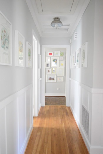Bright hallway gallery with white framed pictures.