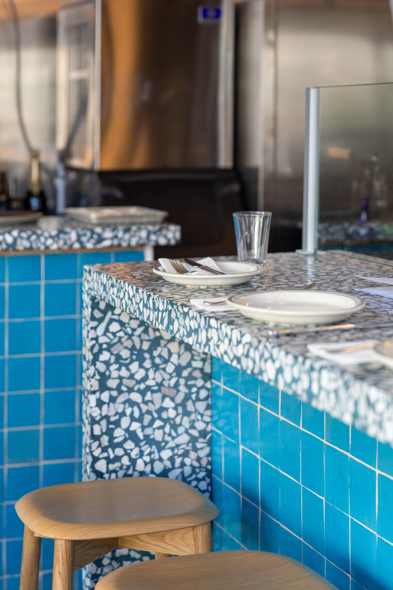 commercial space with black and white patterned countertops and azure blue tiled sides