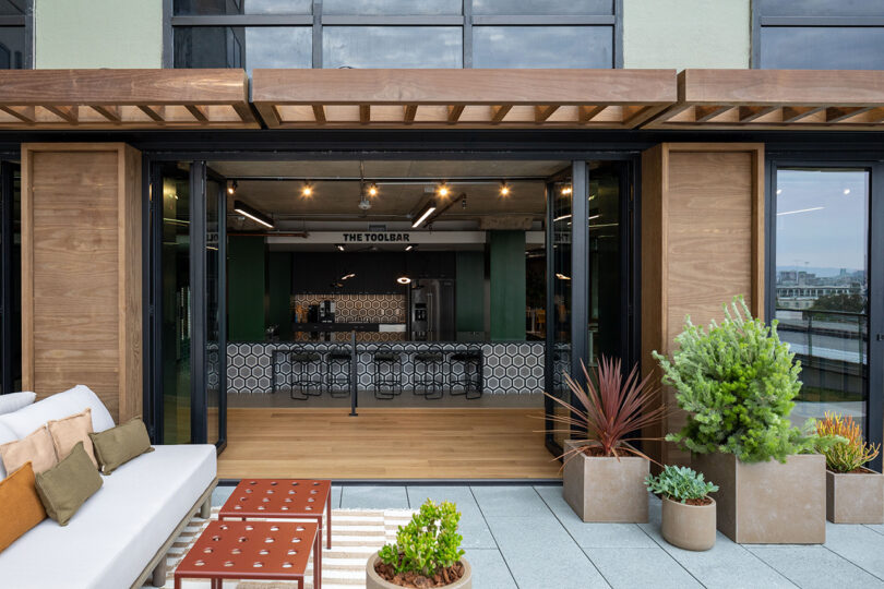 front of a commercial space with cement planters, seating, and two coffee tables