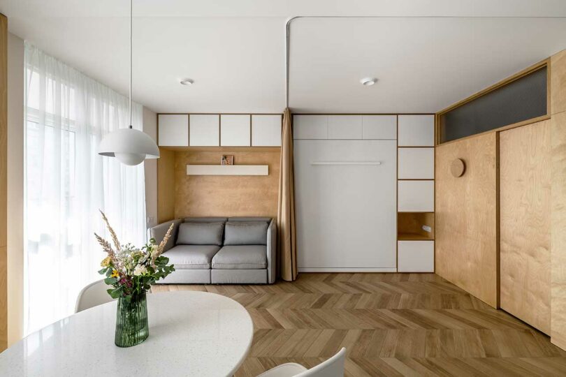 interior view of a small open living space with a built-in sofa and Murphy bed closed on the wall