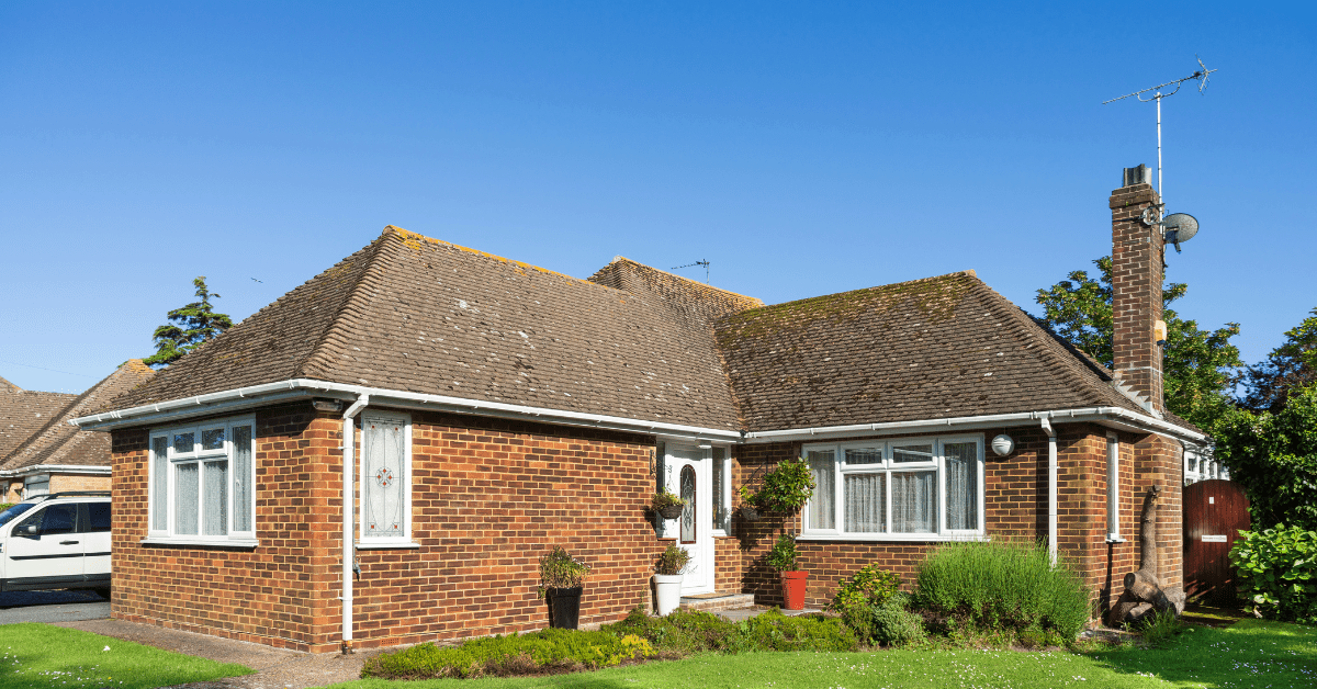 Red brick Bungalow house with white window frames.