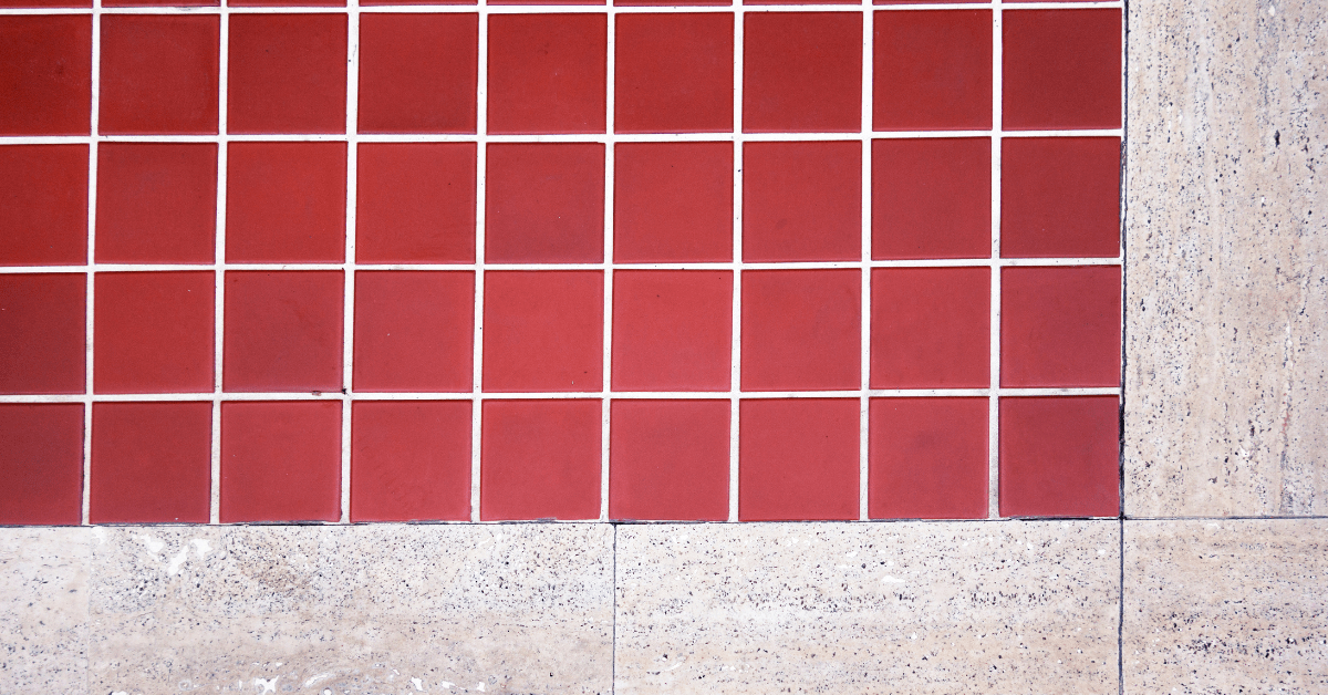 Red terracotta floor tiles surrounded by tile.