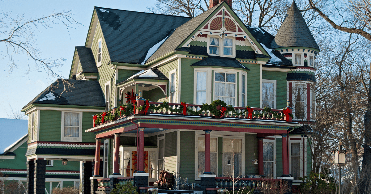 Victorian style house with large windows and green painted exterior walls.