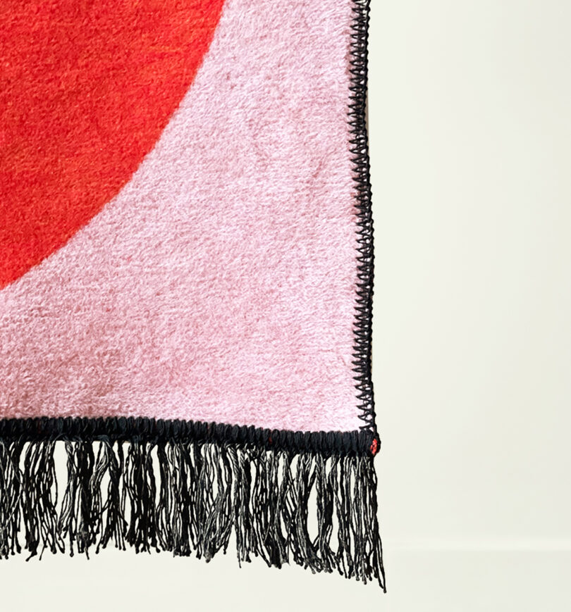 detail of pink, red, white, and black geometric abstract throw blanket