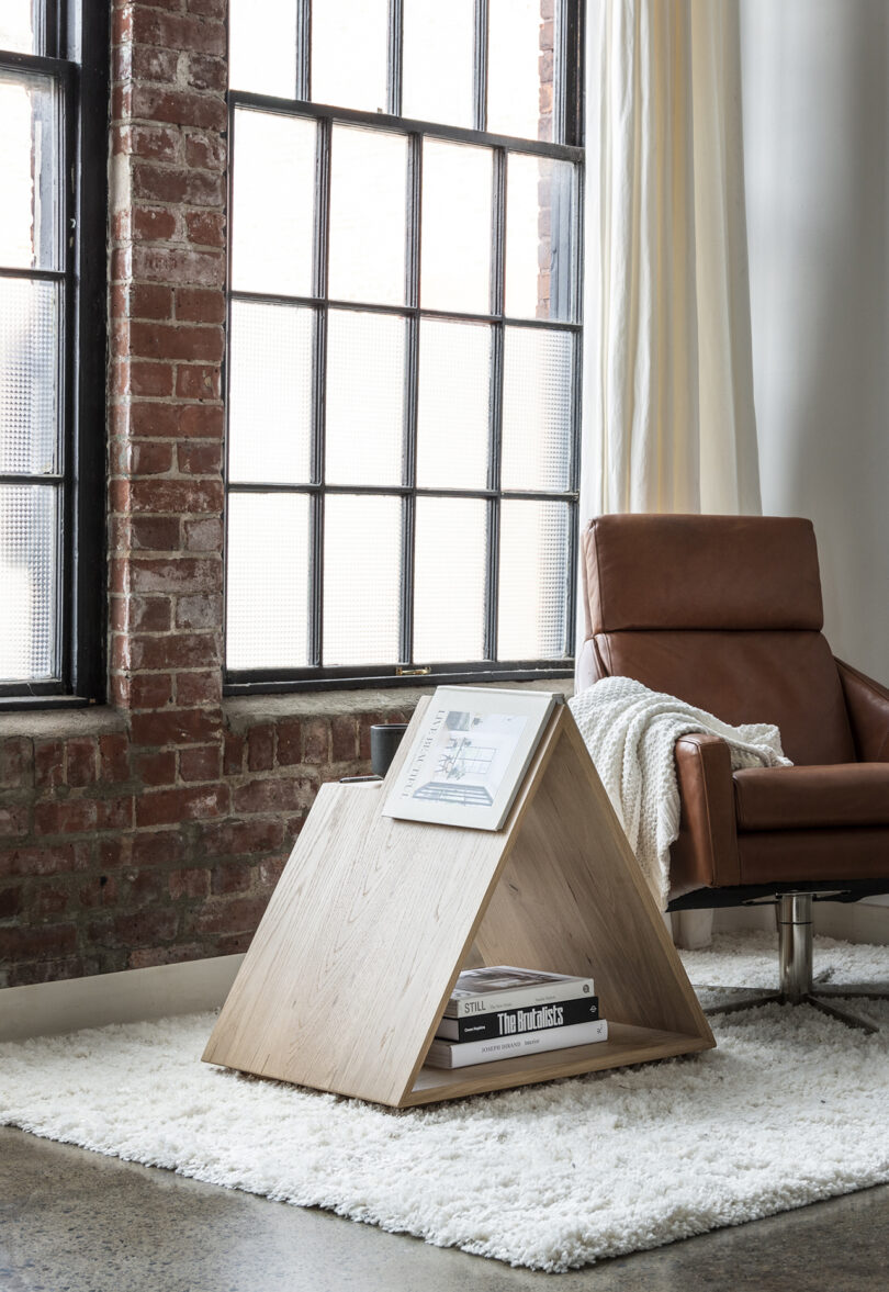 triangle-shaped wooden side table next to a lounge chair
