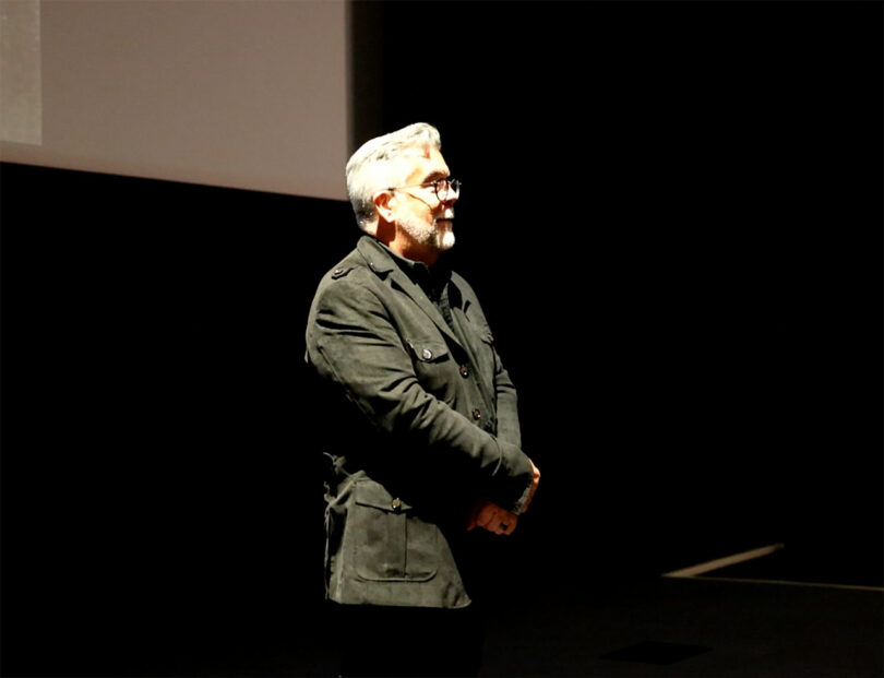 man standing at an angle with armed reached in front holding hands