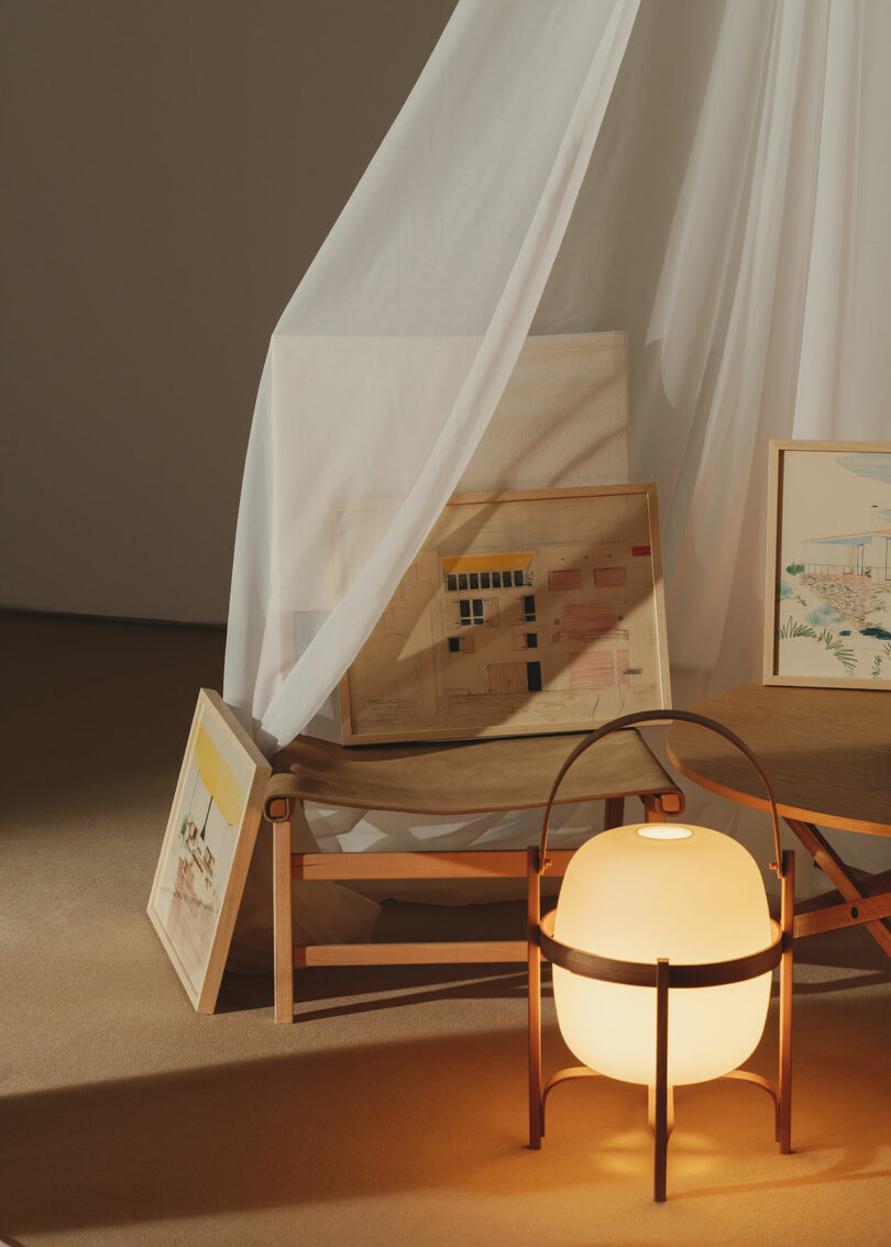 A chair staged with art and lighting under a tent