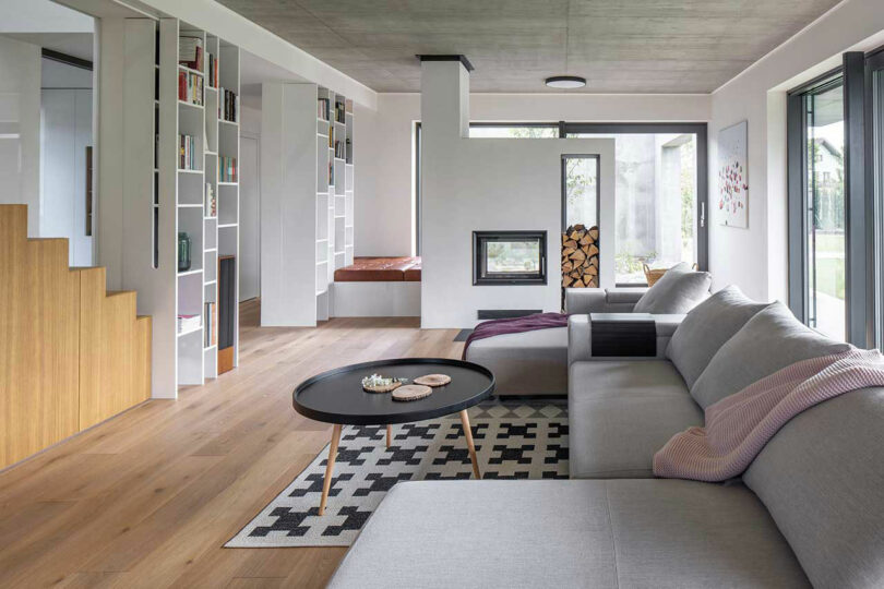 modern living room view with modular light gray sofa, print rug, and built-in shelving