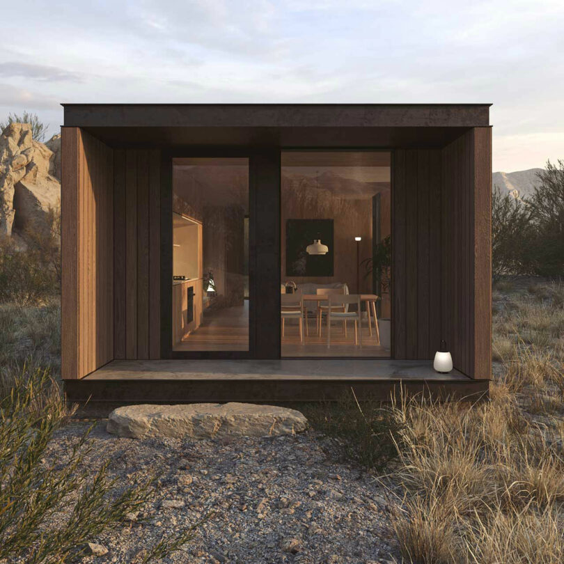 end exterior view of dark brown rectangular tiny home in dessert