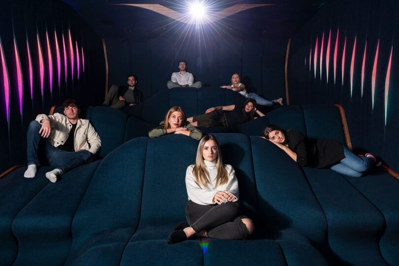 people sitting in a home theater on a blue seating