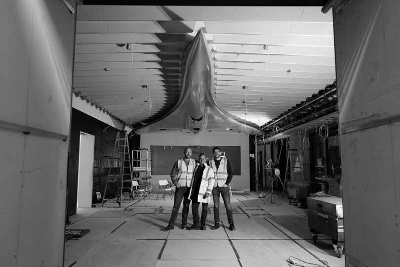 Three of the Discommon team standing underneath the installed Concorde aluminum model