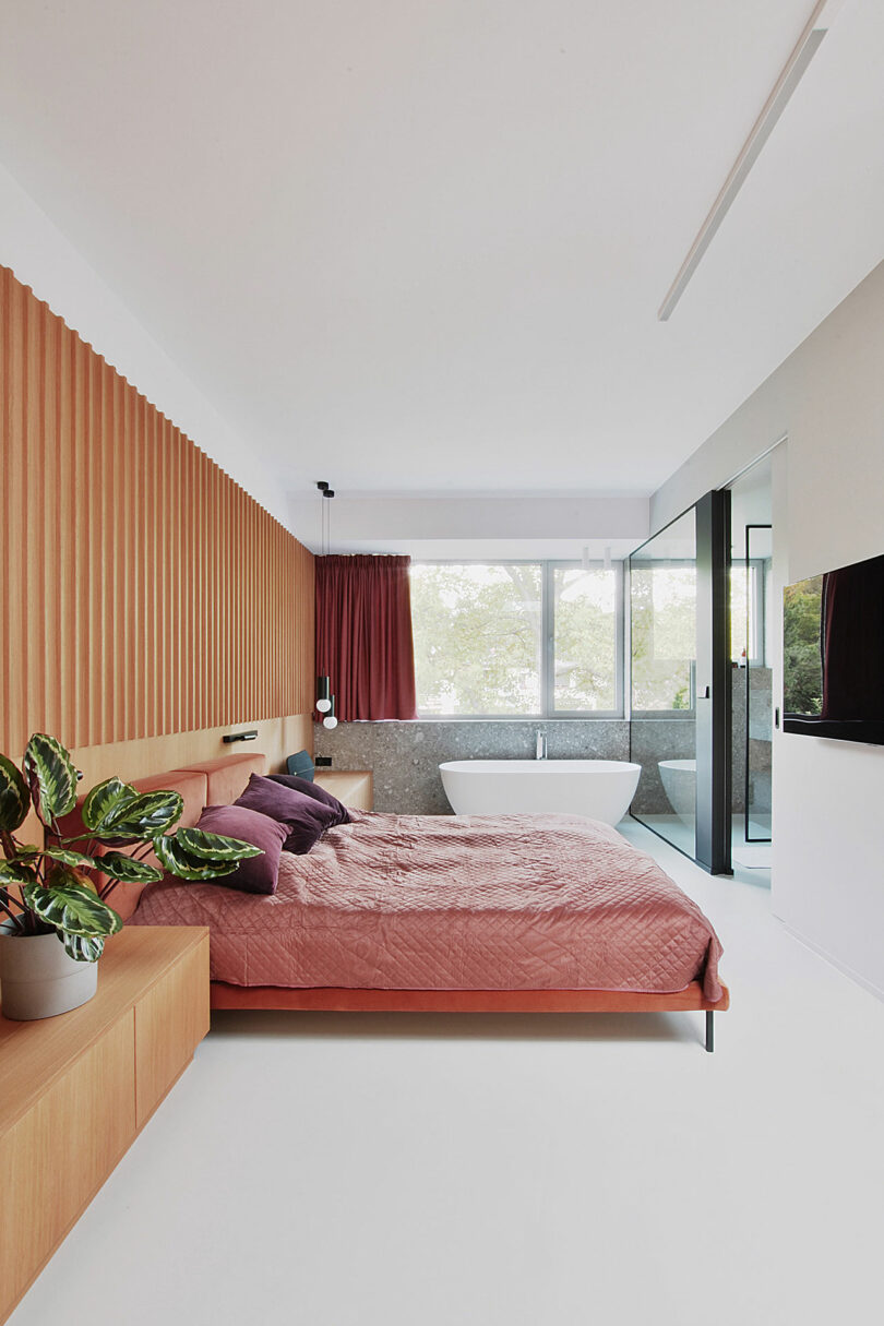 side view of modern bedroom with built-in wood headboard wall and bed with attached tables