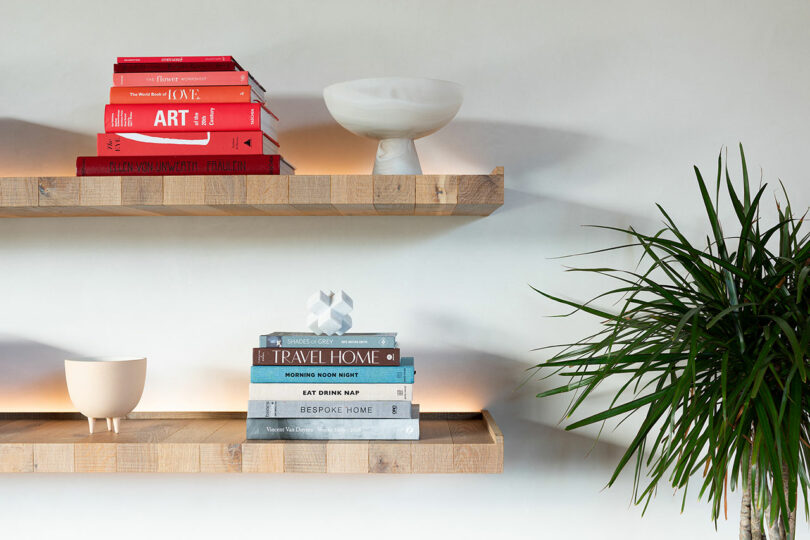 closeup partial view of two floating wood wall-mounted shelves with books