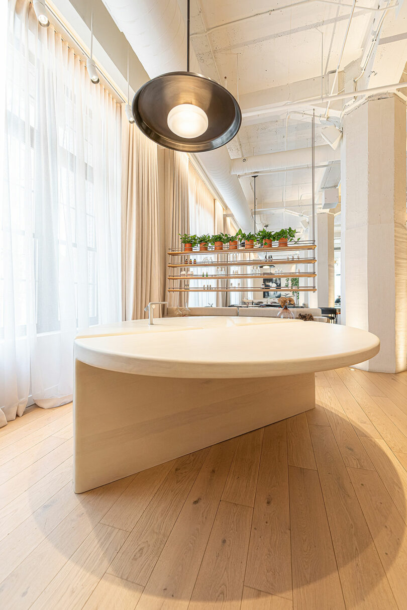 Large round table under minimalist light in a lobby space.