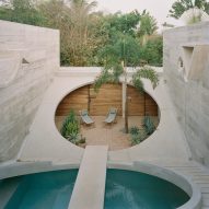 A home with two large cutouts in the center with plants inside