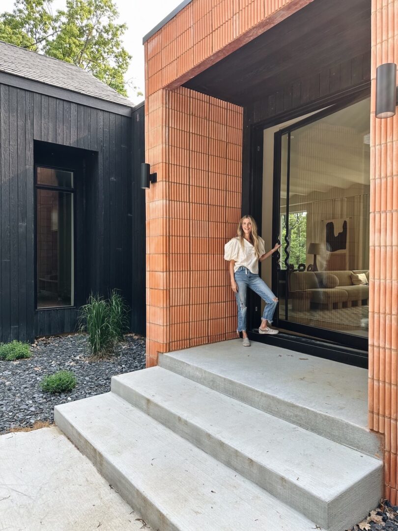 woman standing next to fluted brick wall