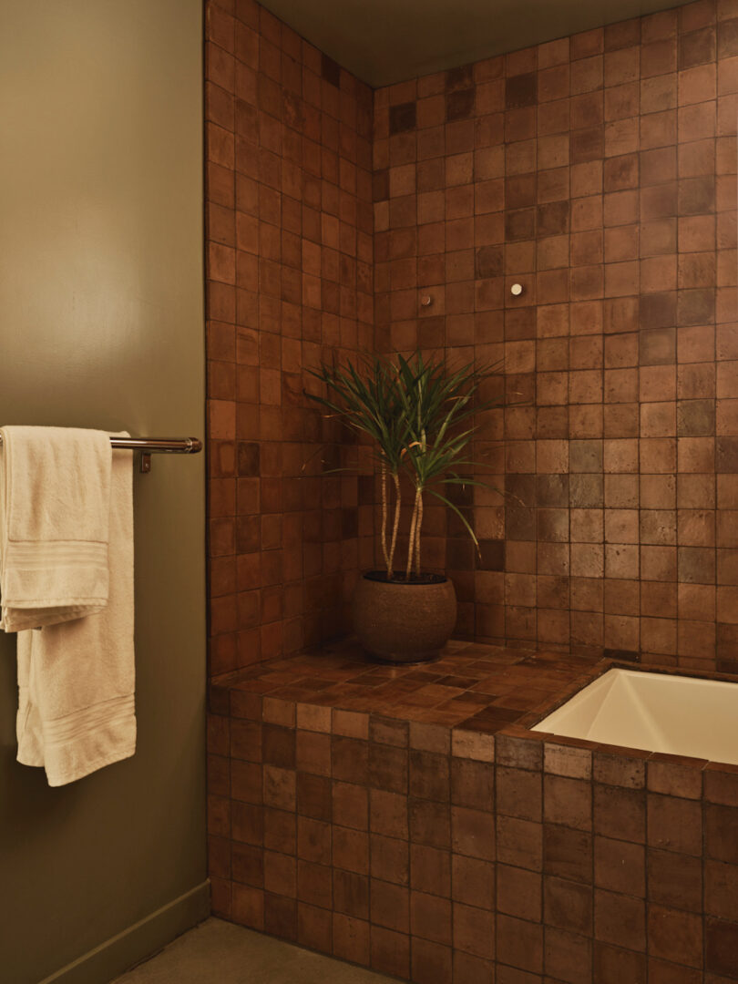 bathroom covered in brown square tiles