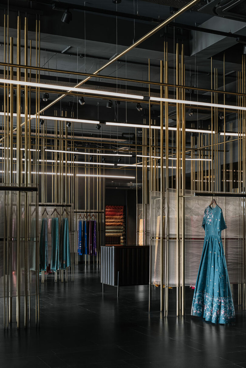 Vertical gold rods from which shelves are built and garments hang.