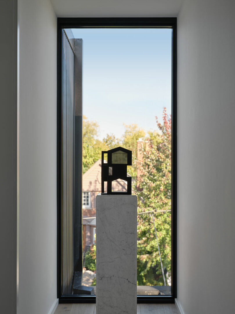 tiny model of modern house sitting on white podium in hallway of modern home it replicates