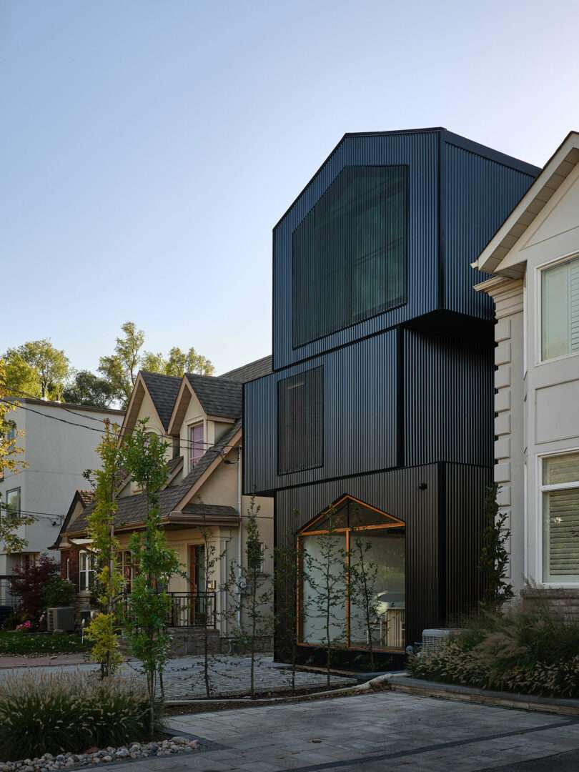 angled front exterior view of modern black three story stacked layer house