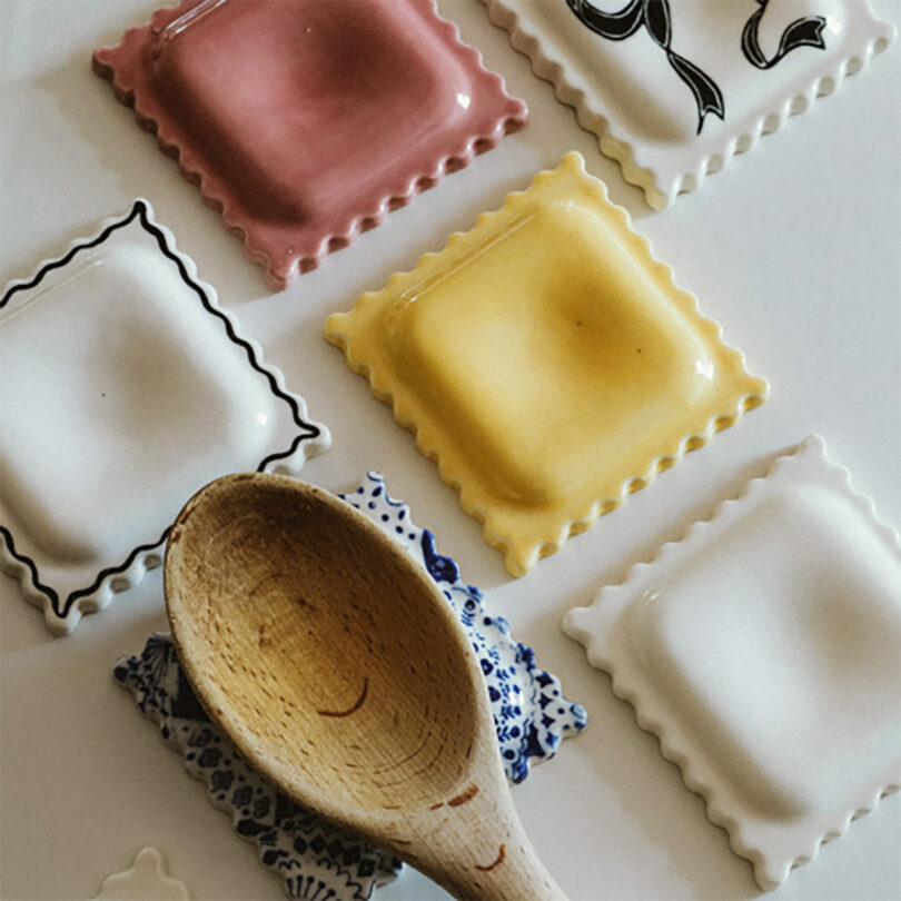 A wooden spoon resting on a ceramic ravioli plate.