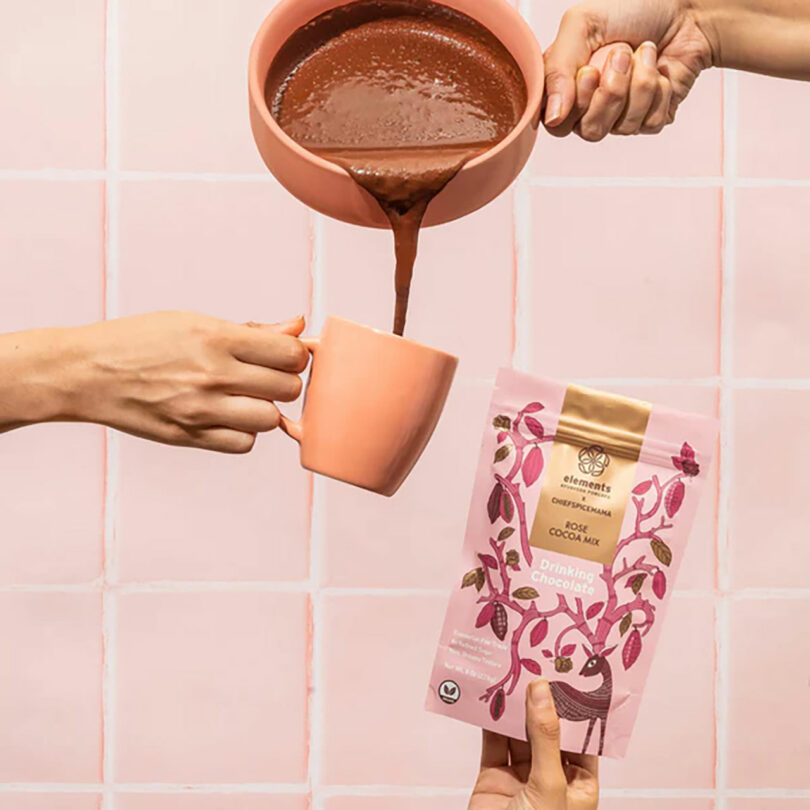 Someone pouring hot chocolate into a mug.