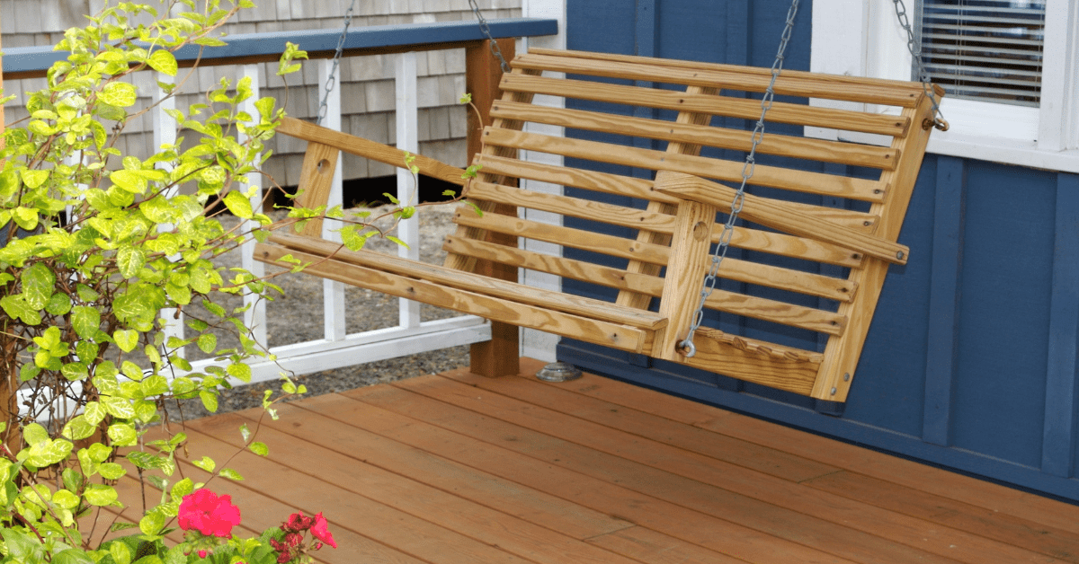 A front porch with swing set and hardwood deck.