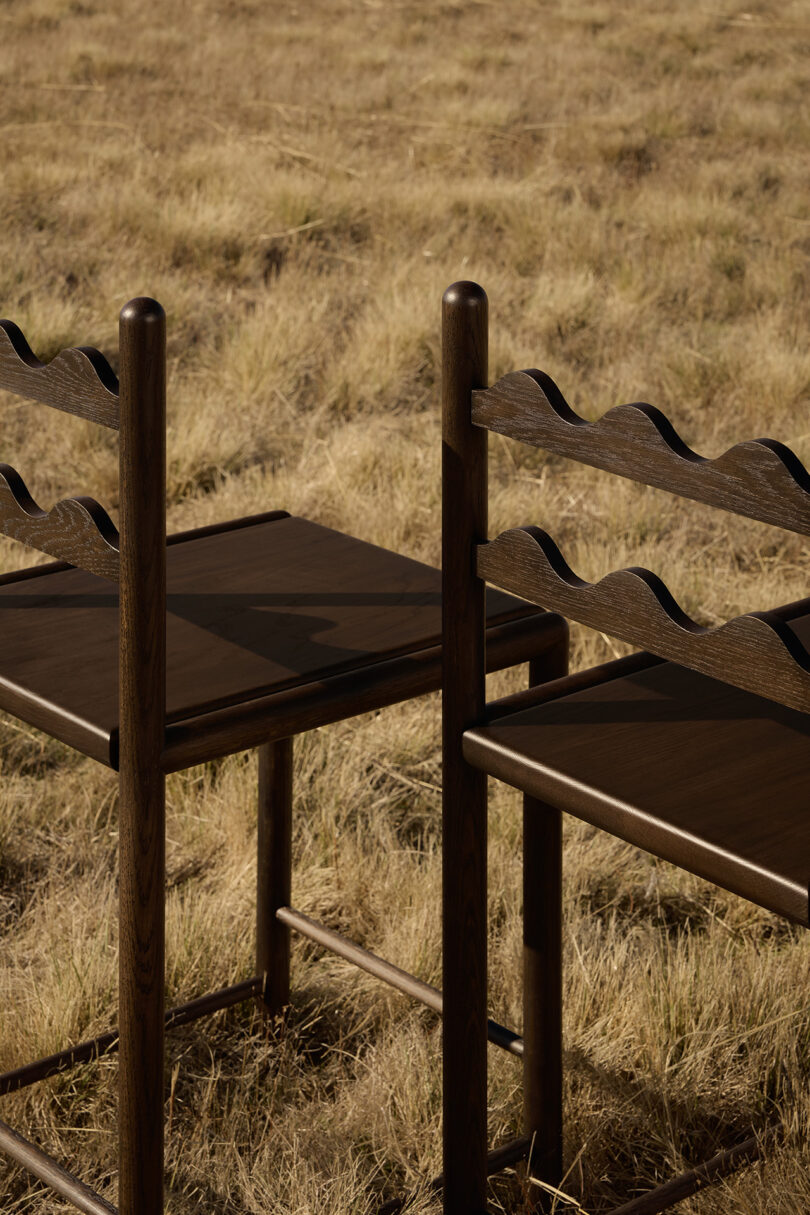 two tall dark wood stools in an off-season field