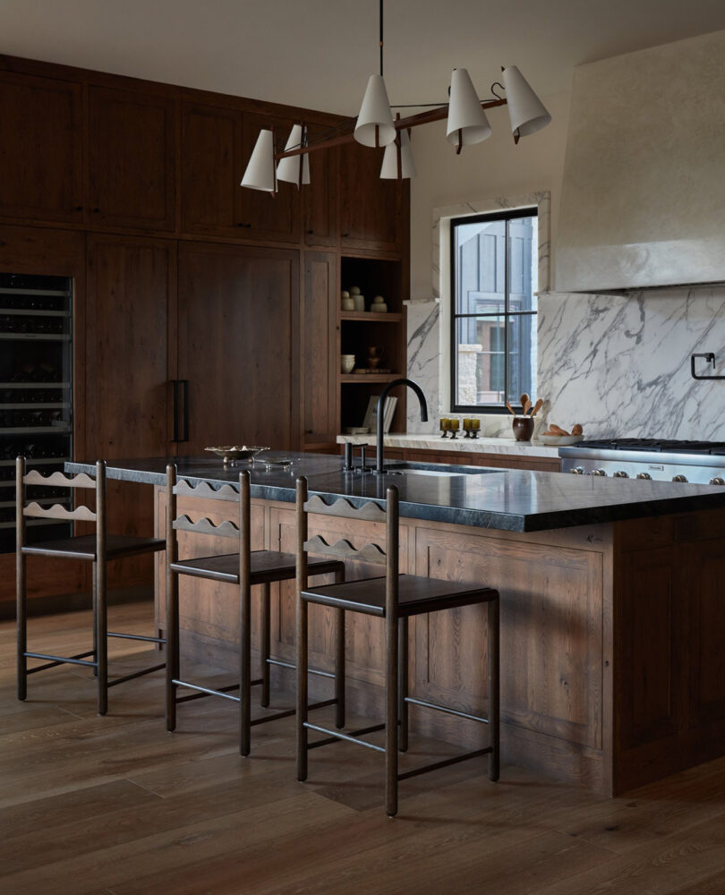 three tall dark wood stools in a styled kitchen