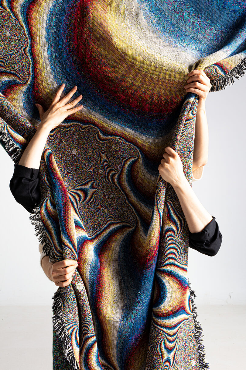 multi-colored patterned textile being held up by a person