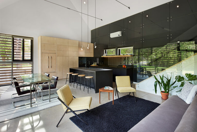 A modern, open plan living space and kitchen with stairs to a loft.
