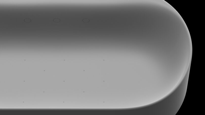 Detail of the minimalist sculpted bath tub right side with small perforation for the jet spa visible along the sides and bottom.