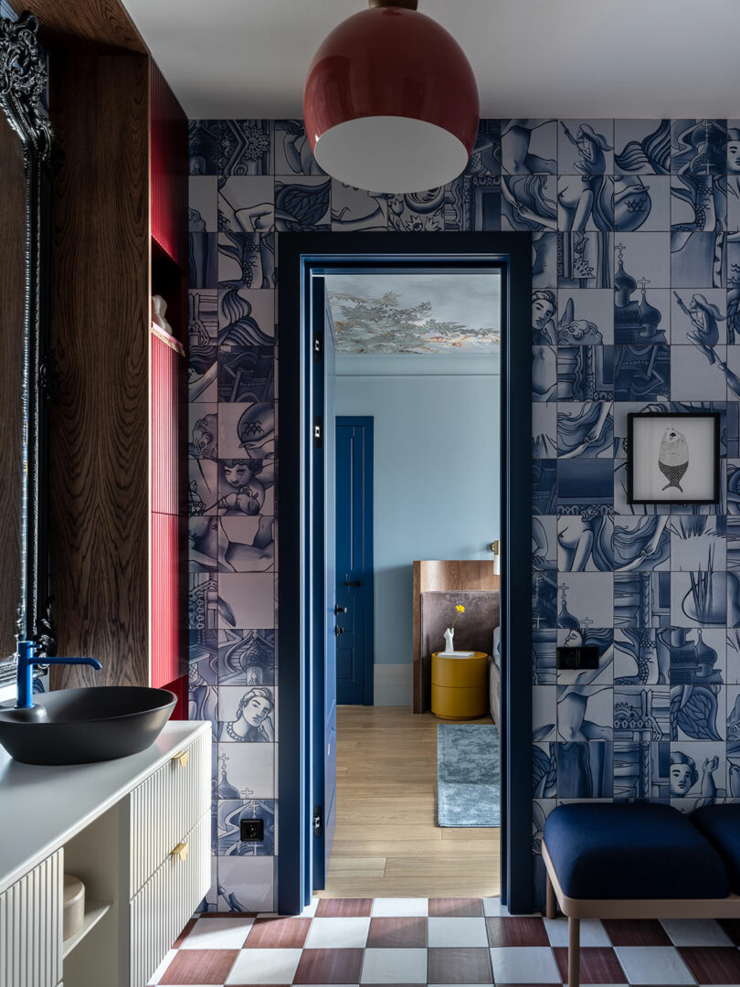 view in modern bold bathroom looking to main bedroom with blue and white patterned walls and black and white checked floor