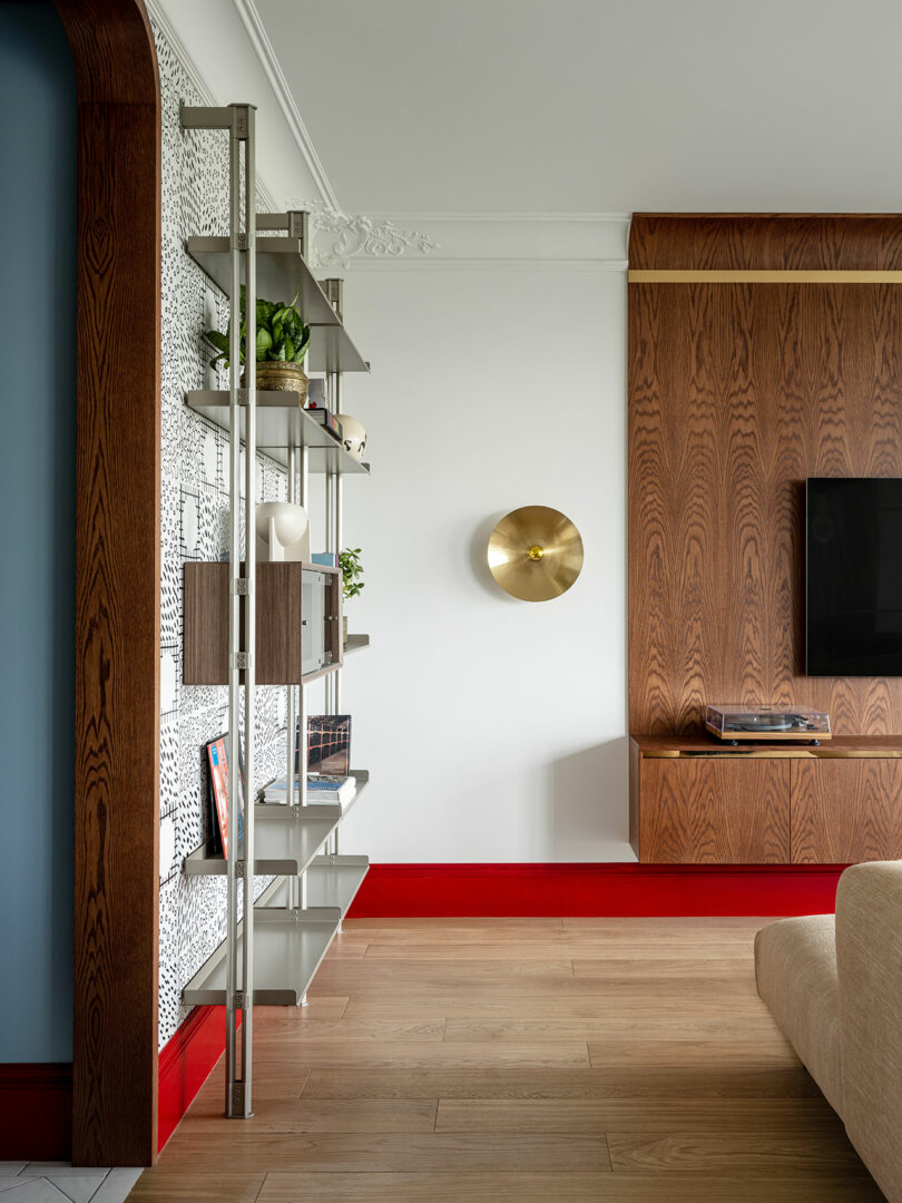 partial view of living room with modern wood feature wall with mounted tv and chrome shelf against the left wall